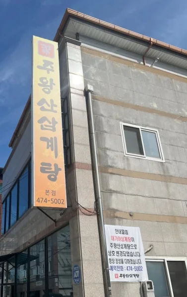 가게 건물 모퉁이 — 세로 간판 «주왕산삼계탕 본점 474-5002», 벽의 상호 변경 안내 현수막